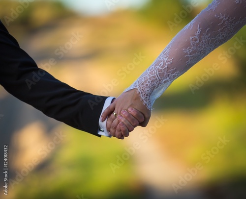 Wedding couple together holding their hands, hands close up