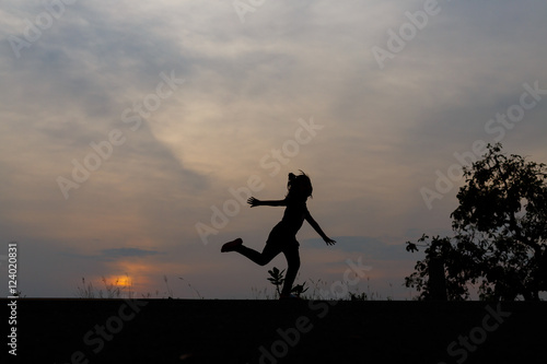 Silhouette girls on holiday. she is happy to be running and jump © weerajata