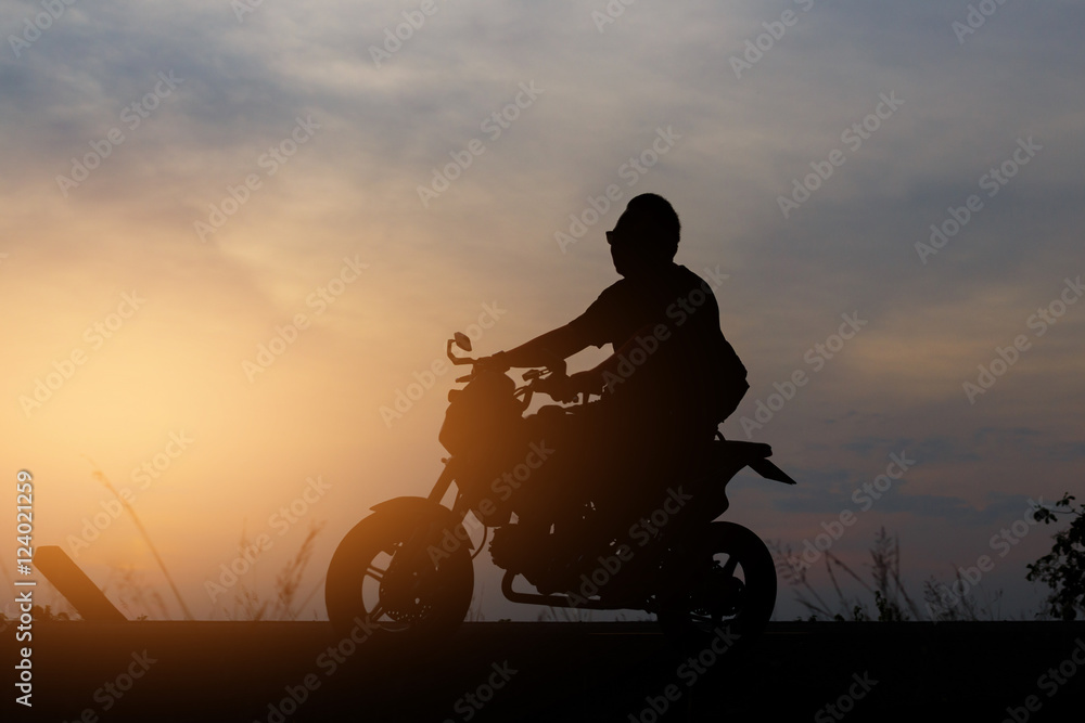 Fototapeta premium Silhouette People riding a motorcycle at sunset