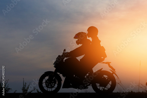 Silhouette People riding a motorcycle at sunset