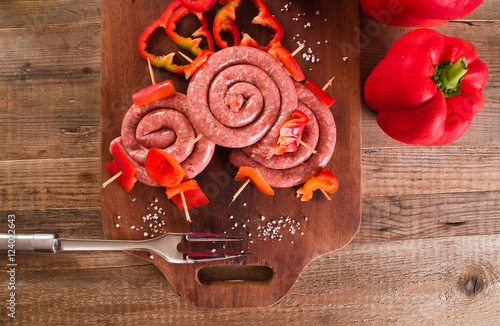 Raw sausage on wooden table.  photo