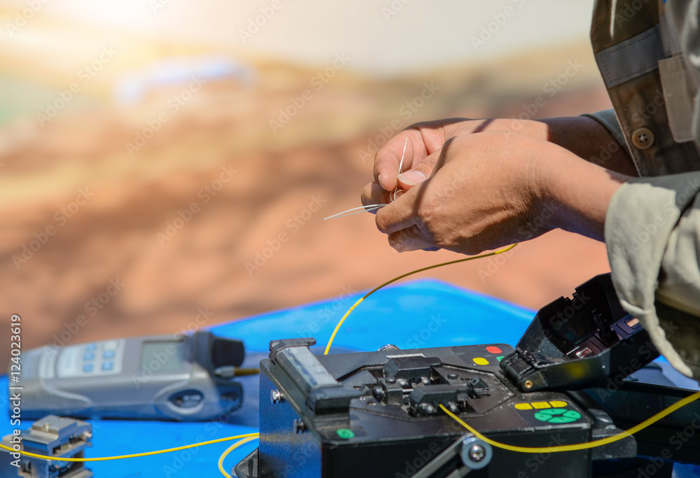 Naklejka premium Technicians are cutting and fusion fiber optic cables.