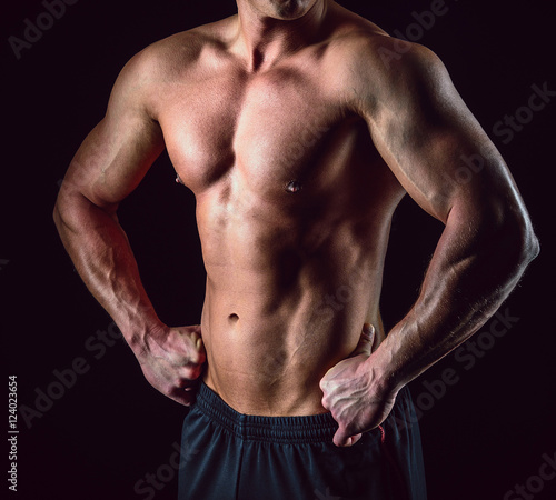 Healthy muscular young man body. Isolated on blcak background