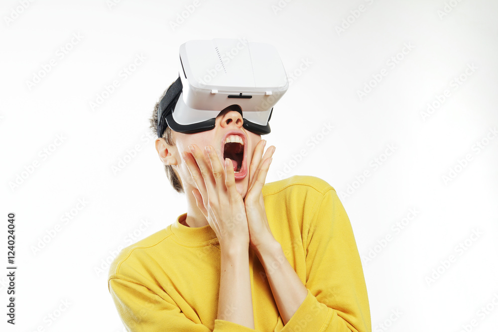 Teenager with virtual reality headset is stunned by VR experience. Teen shocked wearing in vr glasses on a white background. New technologies and young person. Teenager with virtual reality headset is stunned by VR experience. Teen shocked wearing in vr glasses on a white background. New technologies and young person.