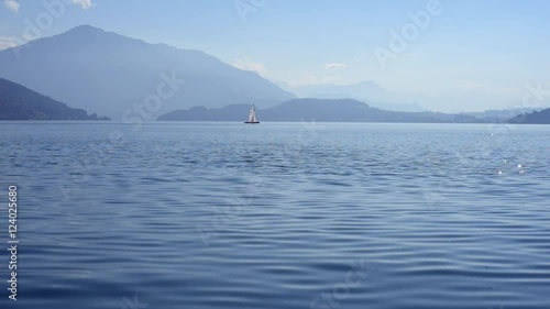 ein Segelboot auf dem Zuger See mit Alpenkulisse im Hintergrund photo