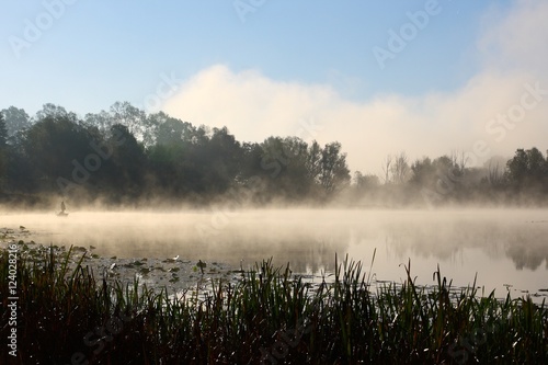 Misty morning on the river. Man fishing in boat. © Simun Ascic