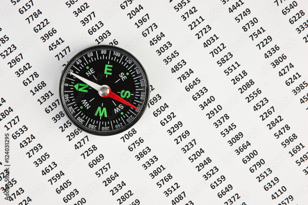 compass on document with columns of figures compass on document with columns of figures