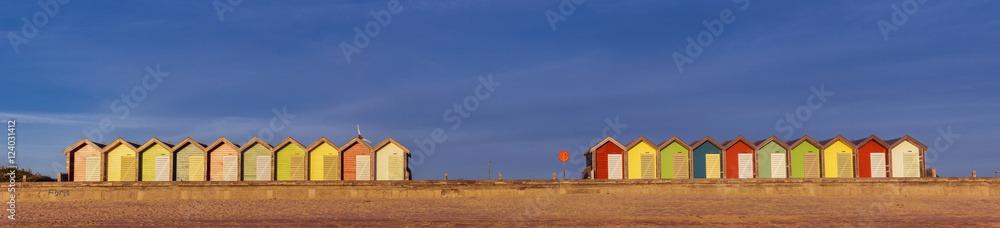 Colourful beach huts at South Beach, Blyth, Northumberland, England, UK. In early morning sunlight. Panoramic view