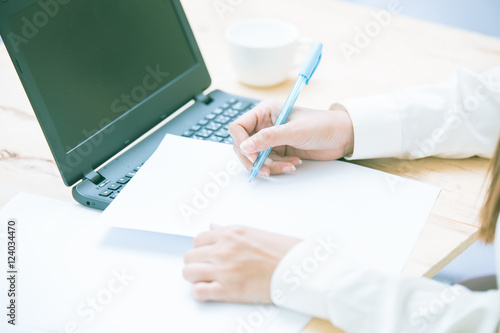 Business women hands working with laptop on wooden desk  lighting effect
