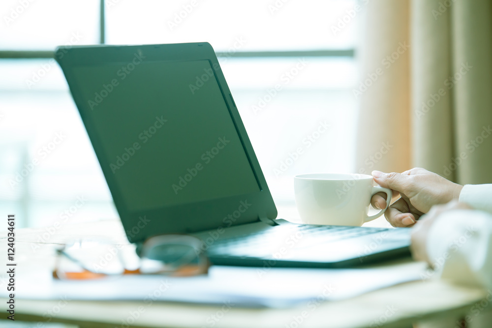 Business women hands working with laptop on wooden desk, lighting effect