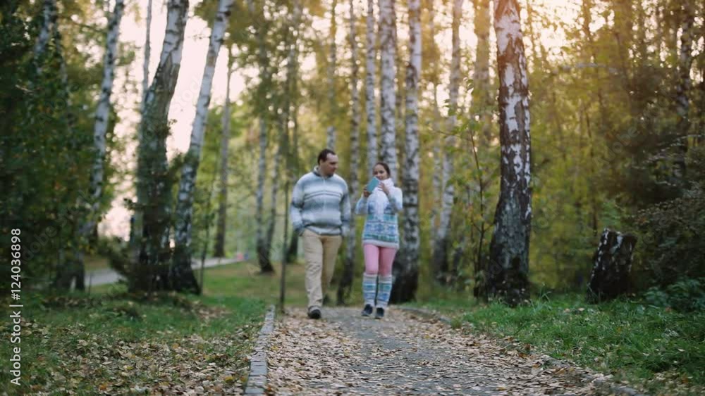 Young couple man and woman wear knitted sweater walking outdoor in autumn forest making selfie. 1920x1080 Young couple man and woman wear knitted sweater walking outdoor in autumn forest making selfie. 1920x1080