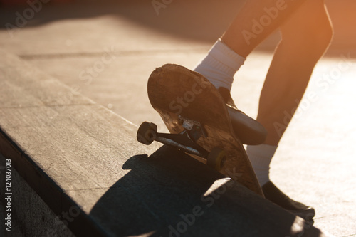 Feet and skateboard. Skater doing grind trick. Perfect coordination of movements. Skill of extreme sportsman.