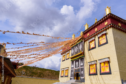 Tibetan Temple, brick wall structure and prayer flags in Shangri photo