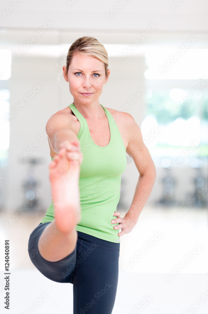 Blond woman practicing yoga in bright studio