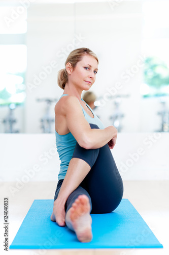 Blond woman practicing yoga in bright studio