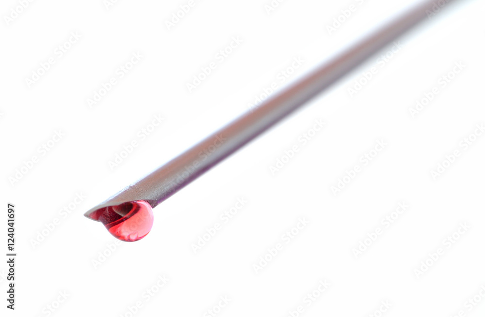 Detail of syringe needle with a drop of blood isolated Detail of syringe needle with a drop of blood isolated