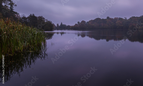 Fototapeta Naklejka Na Ścianę i Meble -  Early morning light on autumn colours at Bolam Lake, Northumberland, England, UK.