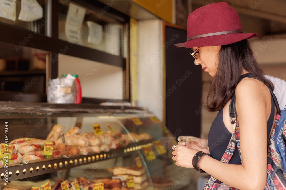 Young woman buys fresh pastries at bakery market