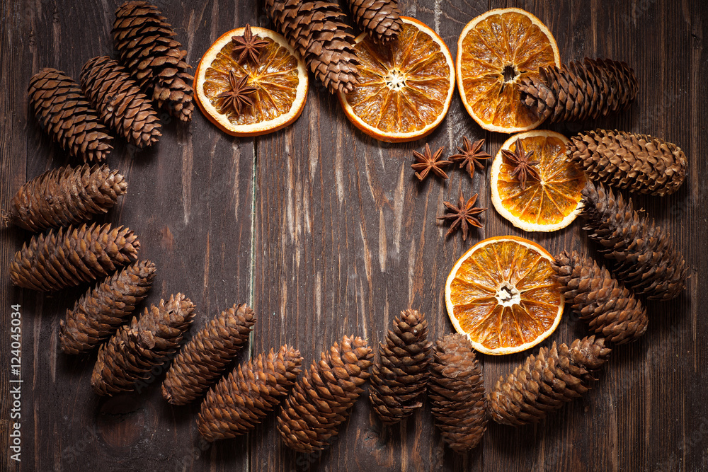 dark wood background with cones, star anise, dry orange with co dark wood background with cones, star anise, dry orange with co