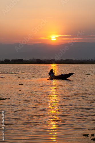Fisherman silhouette at sunset in Inle Lake, Myanmar. Vertical s