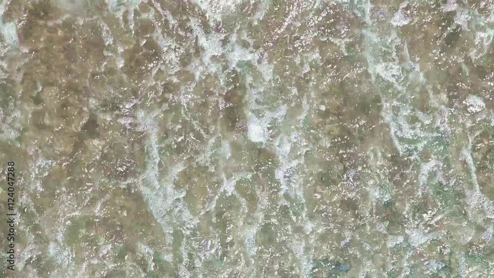 Sea waves and surfs are splashing sand and small pebbles on a seashore
Sea waves and surfs are splashing sand and small pebbles on a seashore