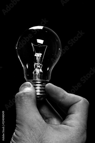 bulb in a hand on black background