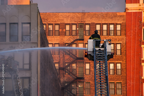 Firefighters spraying water into burning building downtown Chicago