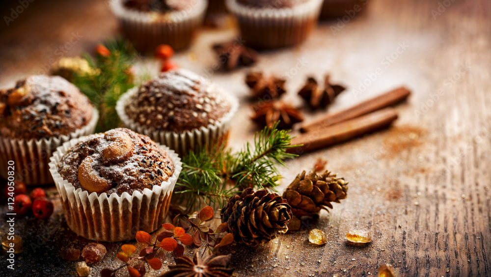 Christmas chocolate walnut muffins among Christmas decoration on a wooden table
