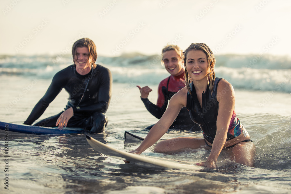 Group of surfers chilling out on the beach.  - obrazy, fototapety, plakaty 