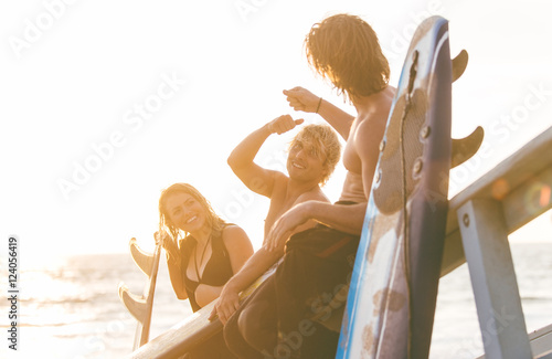 Group of surfers chilling out on the beach.  photo