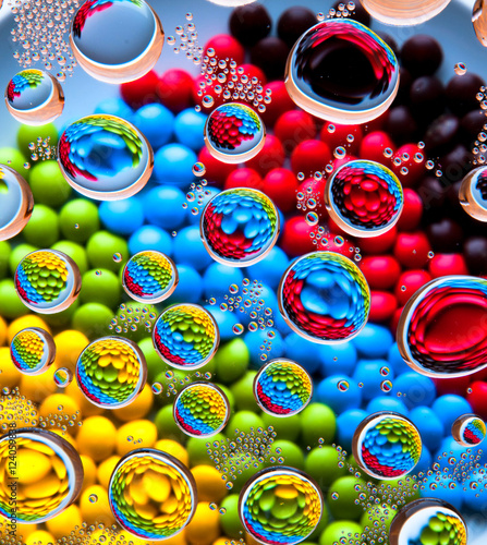 Water drops on colorful rainbow chocolate lentils background