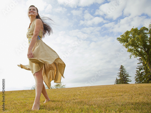 Young Woman Dancing In The Park With A Flowing Dress; Edmonton, Alberta, Canada photo