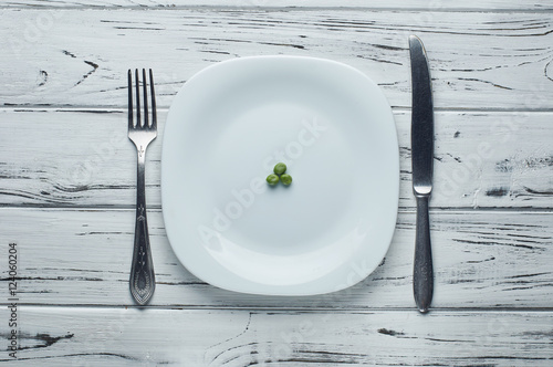 Three delicious peas on a large white plate.
Snack for the diet. Very little food to satisfy your hunger.
