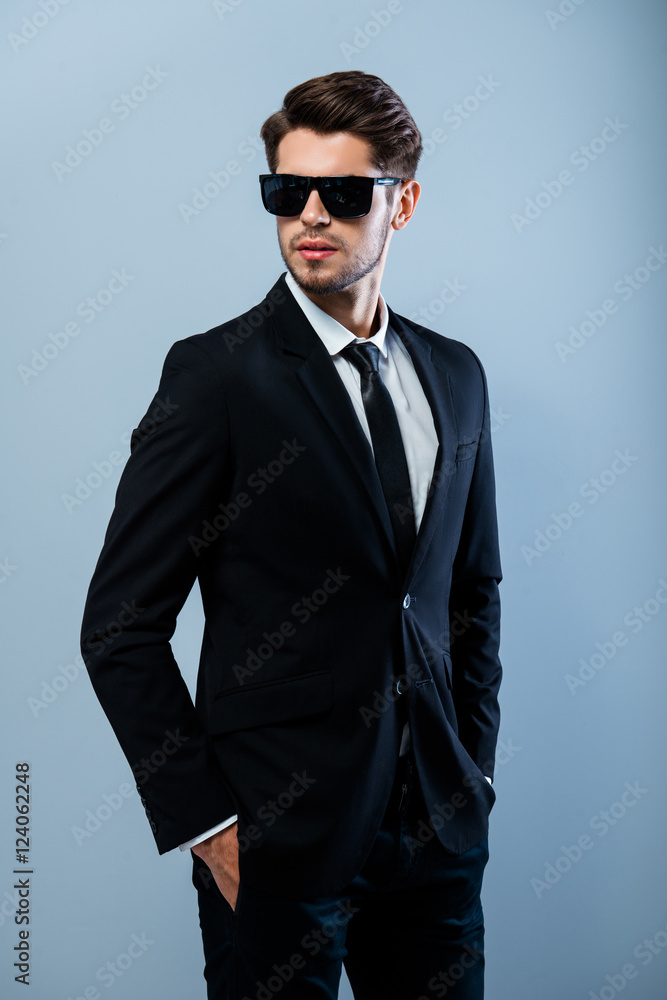Portrait of brutal handsome man in black glasses holding hands i Portrait of brutal handsome man in black glasses holding hands i