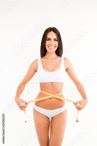 Young healthy woman measuring her waist with tape measure © deagreez