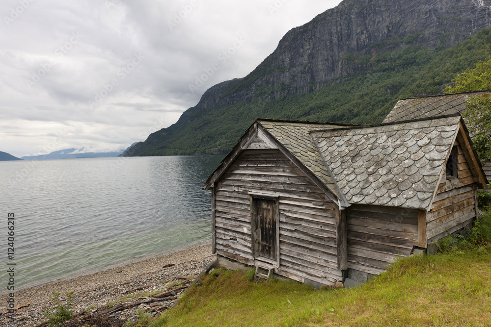 A Weathered Wooden House Along The Water's Edge; Hardangervidda, Norway