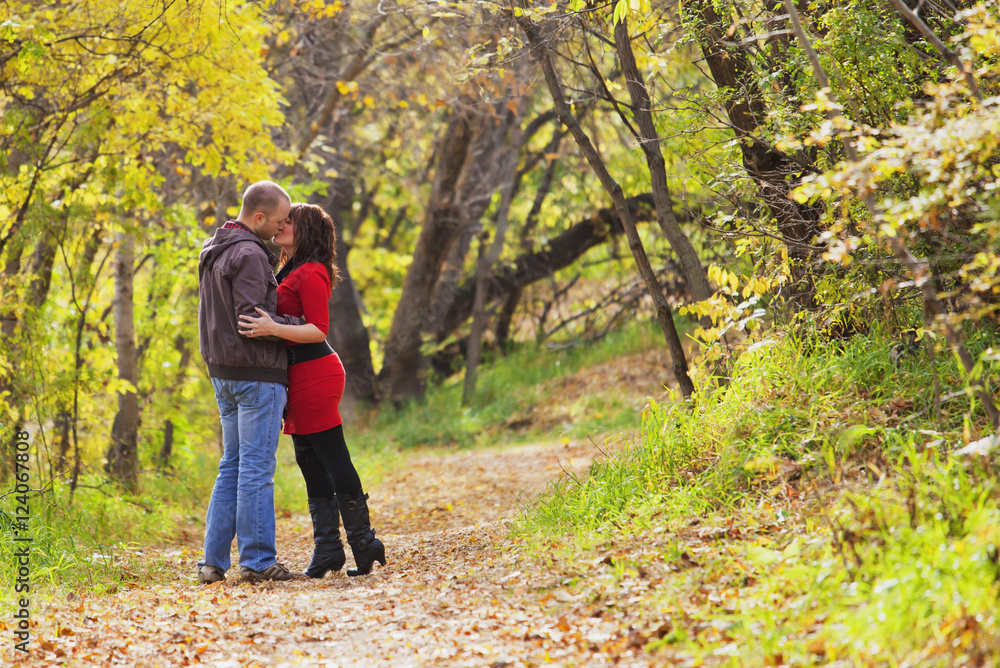 Young Married Couple Kissing While Walking In A Park In Autumn; Edmonton, Alberta, Canada Young Married Couple Kissing While Walking In A Park In Autumn; Edmonton, Alberta, Canada