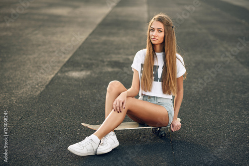 Schilderij op canvas Beautiful young and sexy girl with long hair in a white T-shirt, short shorts an