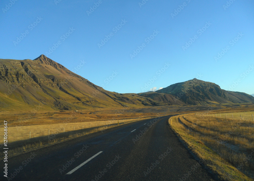 Road along the mountain range in a sunny afternoon, Iceland
