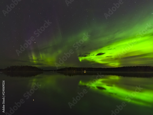 Beautiful aurora borealis over the lake with water reflection. Natural background.