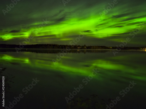 Beautiful green northern lights over lake water. Natural poster.