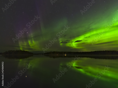 Beautiful green and purple northern lights with water reflection. Natural poster.