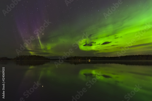 Beautiful green and purple northern lights over a lake. Natural poster.