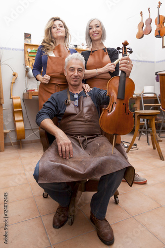 group of mature violin maker in pose