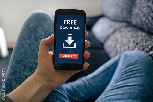 Vászonkép Girl holding smart phone with free download concept on screen