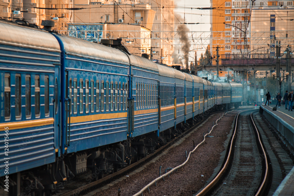 The big old train is going on ukrainian railways. City buildings are on   are waiting on platform - Odessa railway station. The  city is on background Stock Photo | Adobe Stock