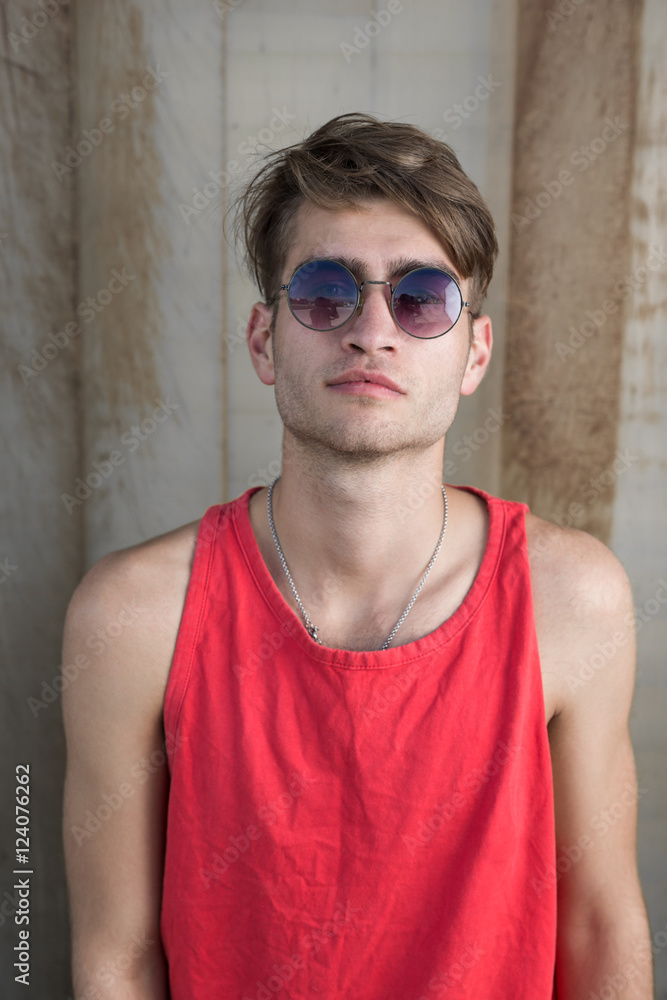 cool street skateboarder with sunglasses in front of iron wall. cool street skateboarder with sunglasses in front of iron wall.