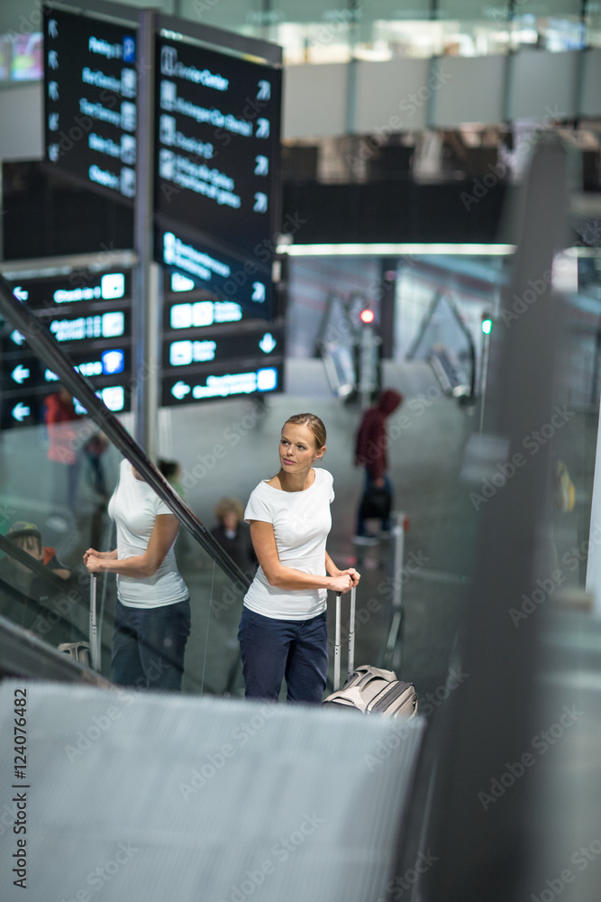 Fototapeta premium Young female passenger at the airport, using her tablet computer