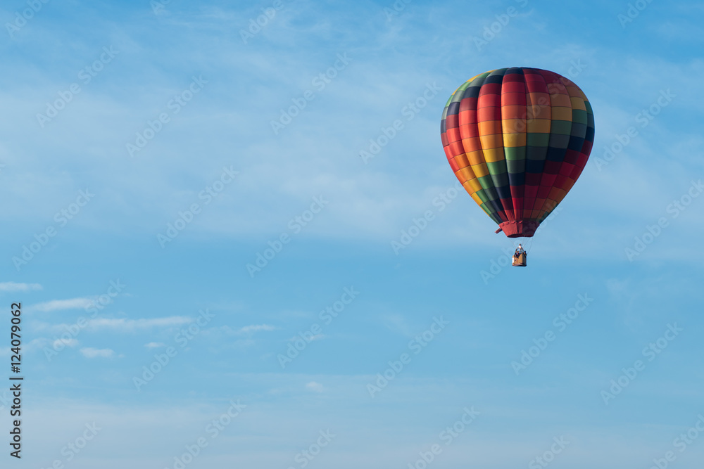 This is a photo of a beautiful hot air balloon slowly sailing through a calm blue sky. This is a photo of a beautiful hot air balloon slowly sailing through a calm blue sky.