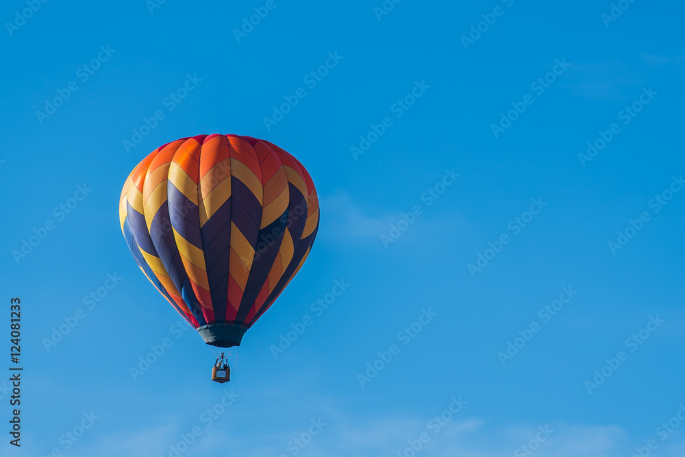 This is a photo of a beautiful hot air balloon slowly sailing through a calm blue sky. This is a photo of a beautiful hot air balloon slowly sailing through a calm blue sky.